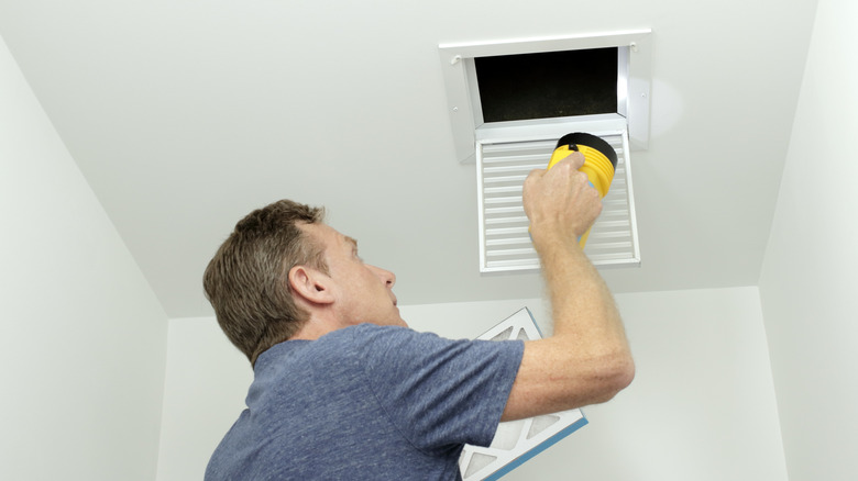 man inspecting air ducts