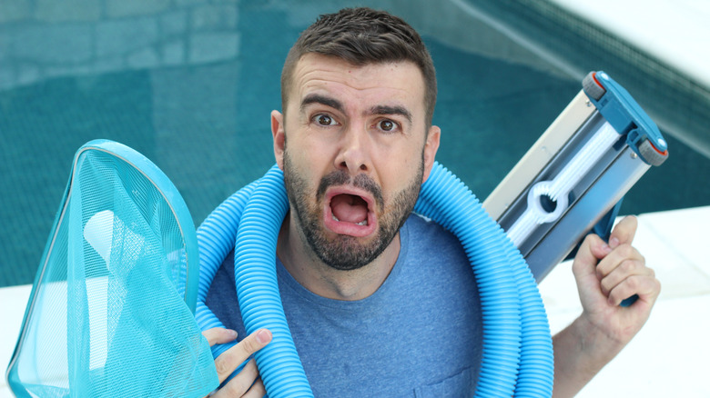 man with pool maintenance equipment