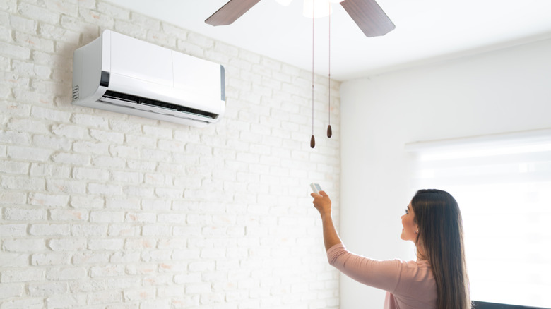 Woman adjusting temp on AC