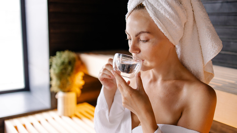 Woman drinking water in a sauna