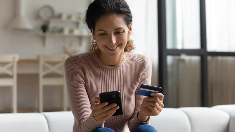 woman holding phone and card