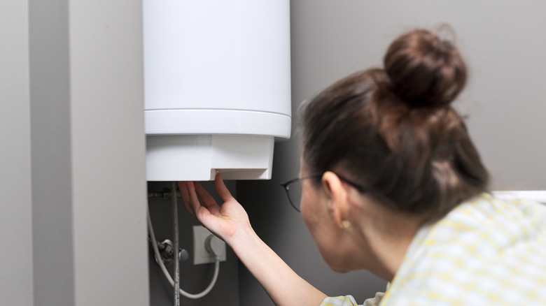 woman adjusts water heater system