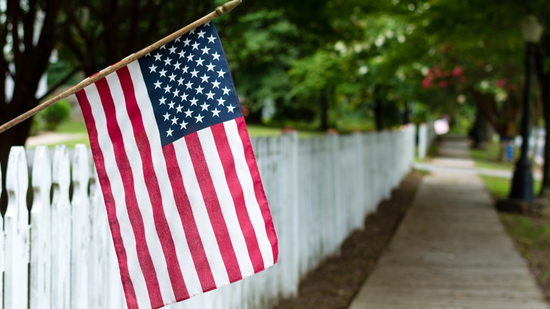 Flag on white picket fence