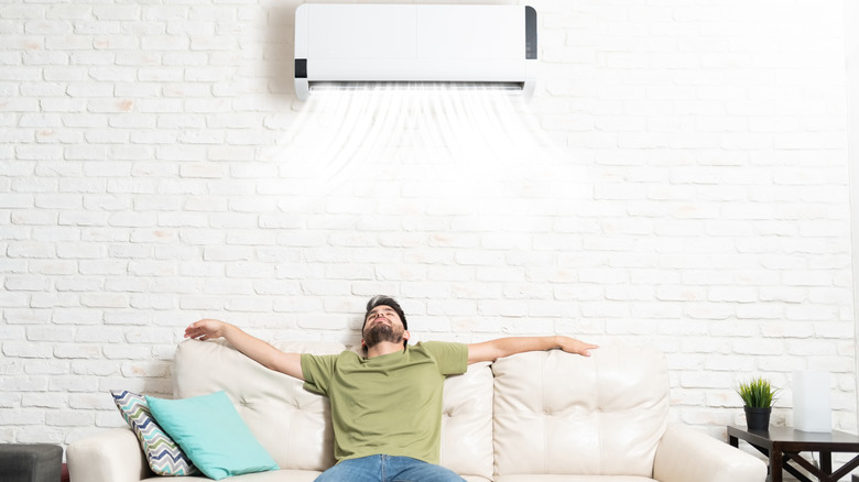 man relaxing under air conditioner