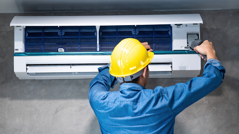 technician repairing air conditioning unit