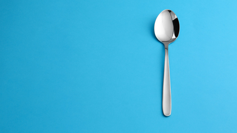 A tablespoon on blue backdrop