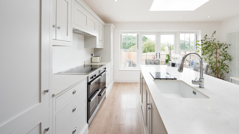 A modern white kitchen with pristine quartz counters.