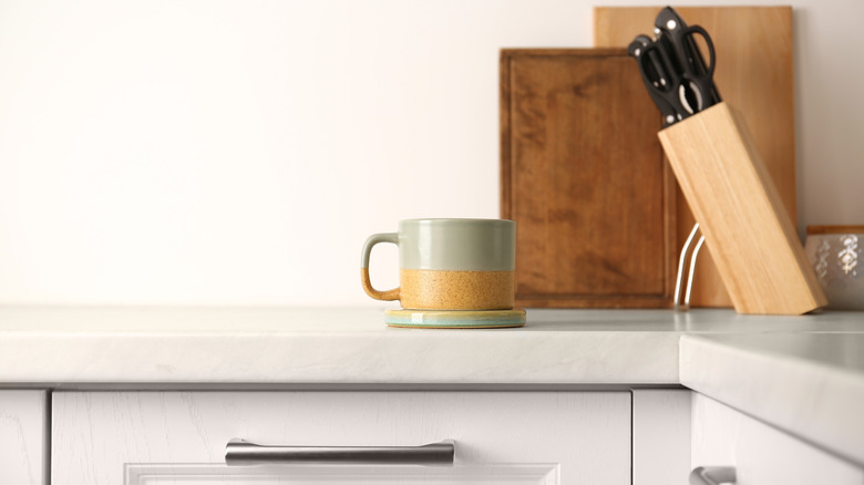 Hot mug with coaster on top of kitchen counter