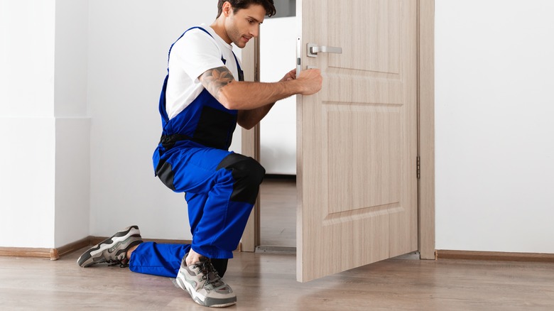 Someone installing an interior door