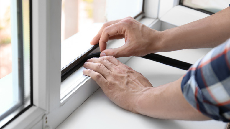 Person repairing window seal