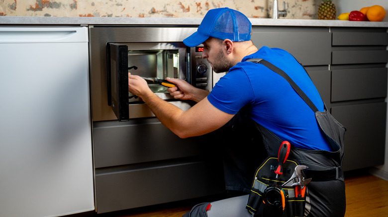 man installing microwave under counter