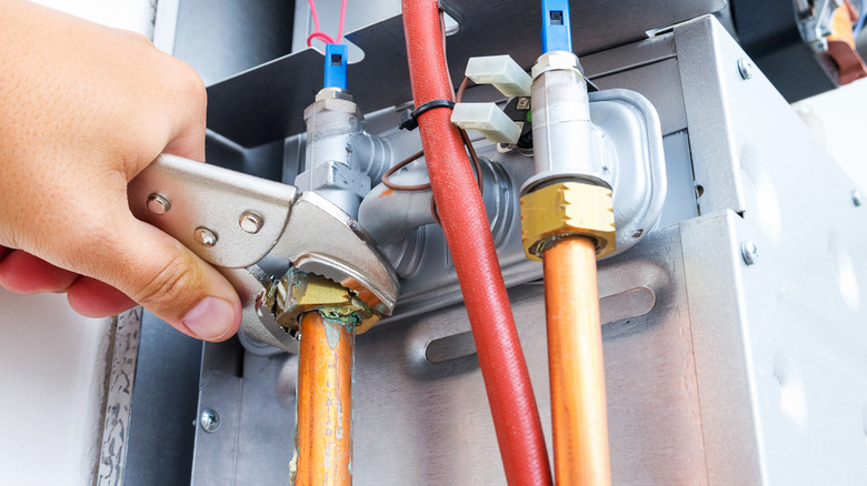 Person repairing boiler with wrench