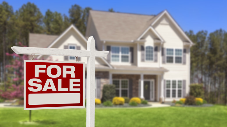 "For Sale" sign and house