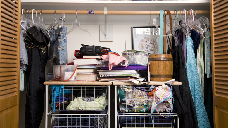 A messy closet with clothes