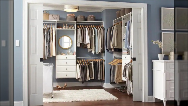 A white modular closet system is installed in a beautiful and organized primary closet