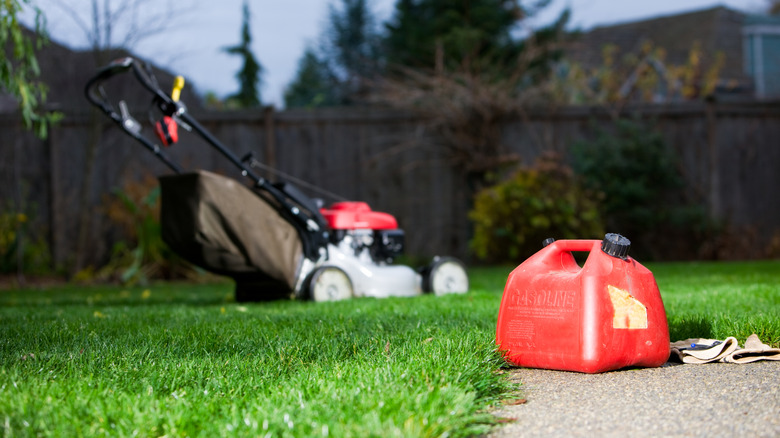  can of gas with lawnmower in the back