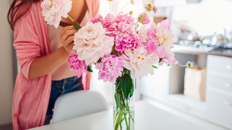 woman arranging flowers in vase