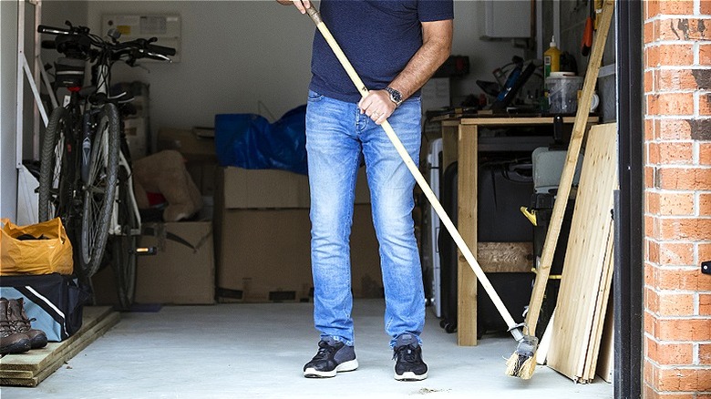 person sweeping garage