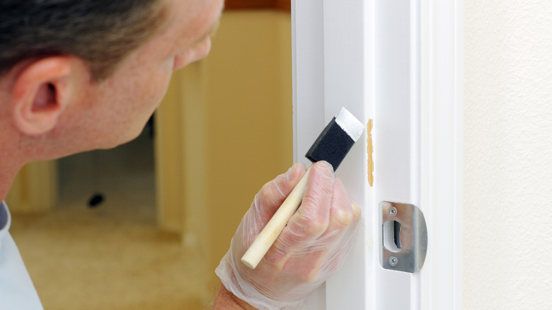 Man touches up door paint