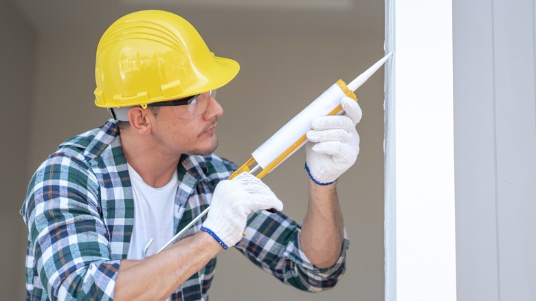 Construction worker with a caulking gun