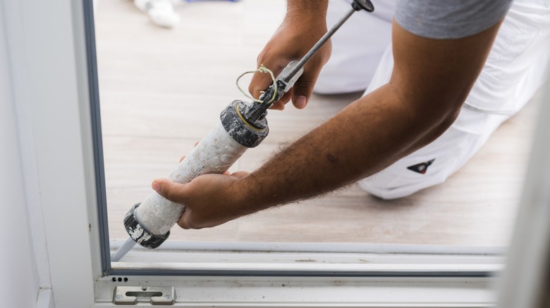 A close up shot of a person caulking