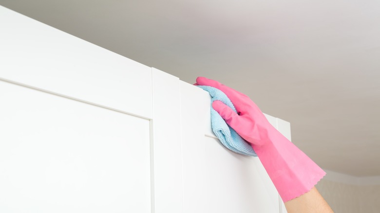 Person wiping down cabinet top