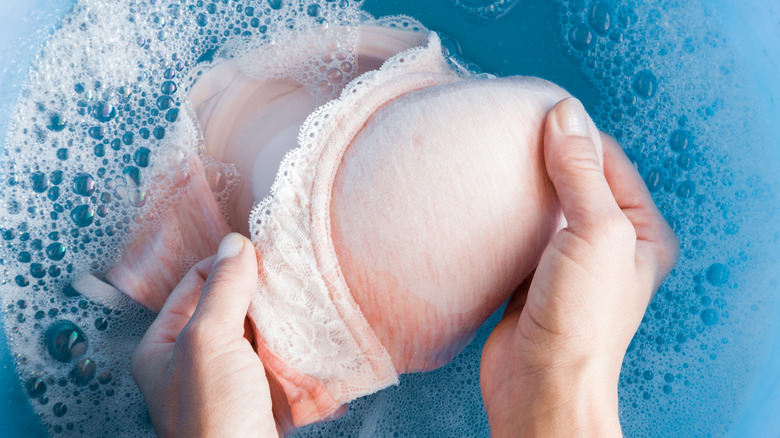 Woman washing bra in water