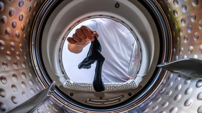 Woman putting sock in laundry
