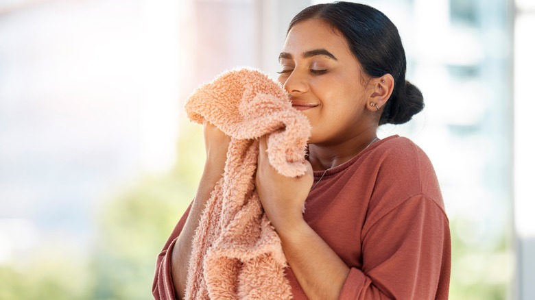 Woman smelling clean towel