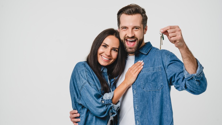 Couple smiling holding keys