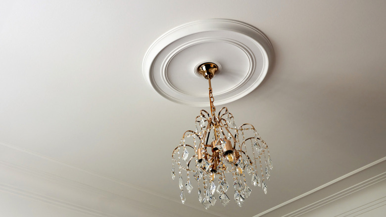 Ceiling rose with crystal chandelier hanging from the center