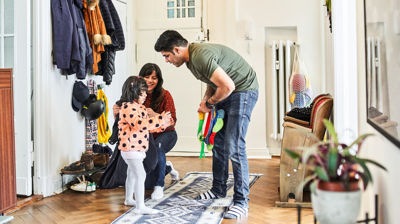 parents putting backpack on daughter