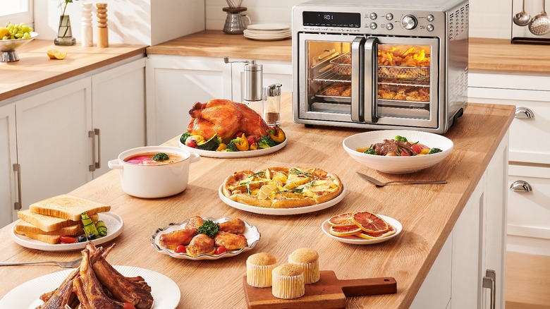 Flexify oven surrounded by counter and oven full of food made with all 10 of the oven's functions