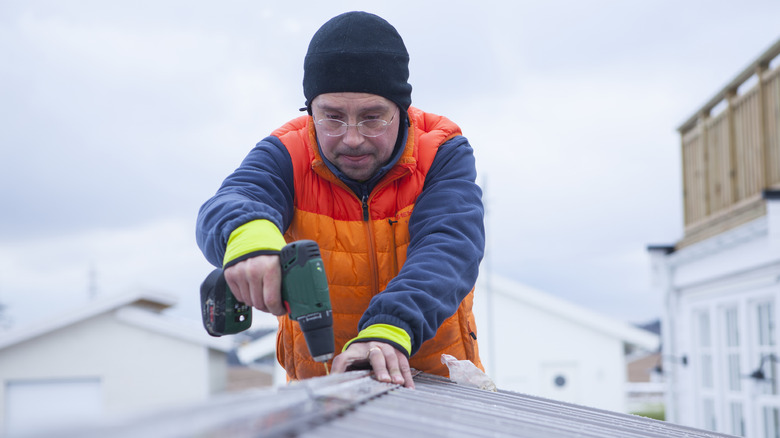 man using drill in winter