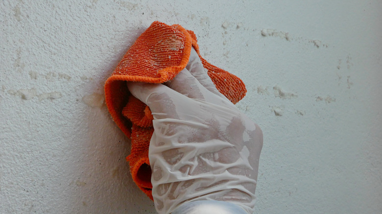 applying paint thinner on wall