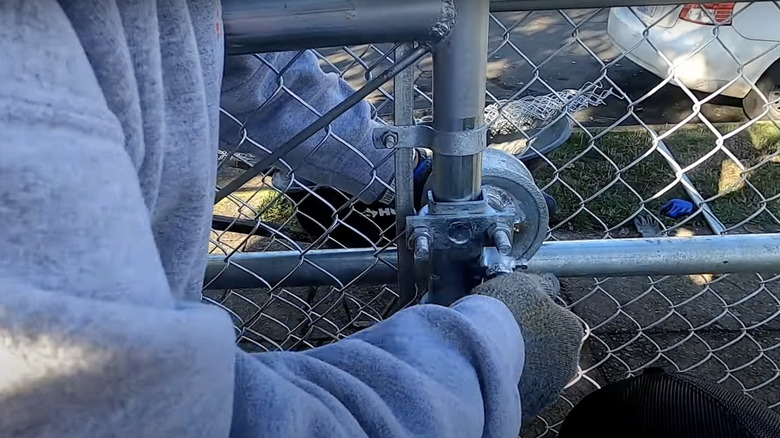 Person installing a sliding chain link gate