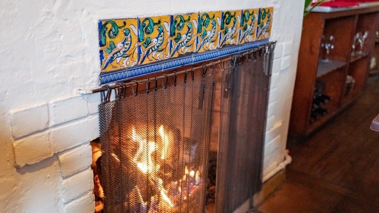 Fireplace decorated with yellow, blue, and green tiles