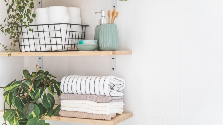 A bathroom shelf is neatly organized with baskets and containers