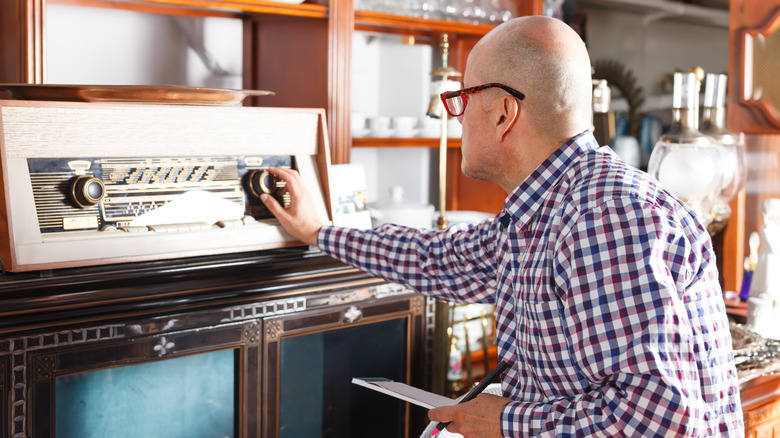 Antique shop owner examining an item