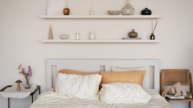 A bed flanked by a table on one side and a chair on the other