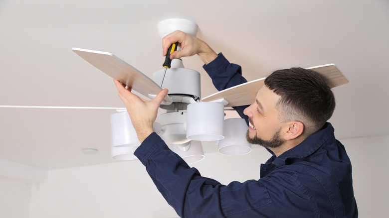 Man screwing ceiling fan blade