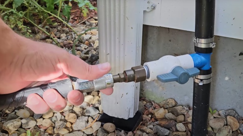 Person attaching an air compressor to a sprinkler system