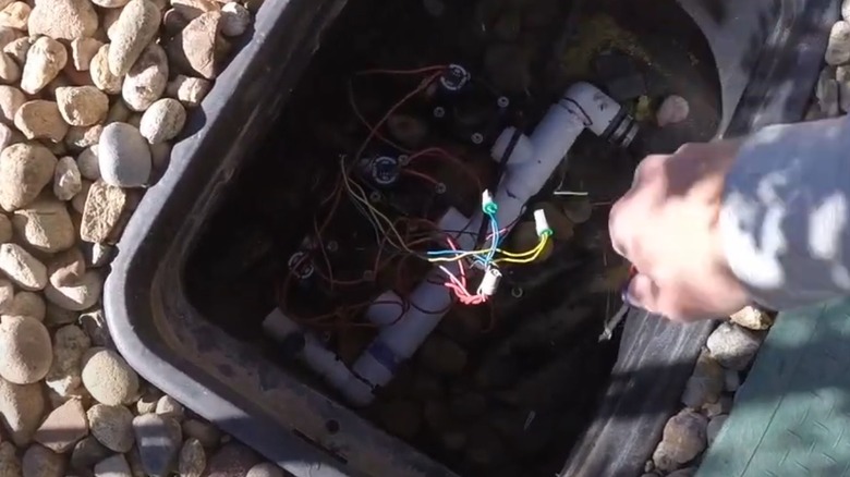 Person draining a lawn sprinkler system manually