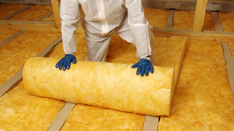 Person unrolling insulation batting