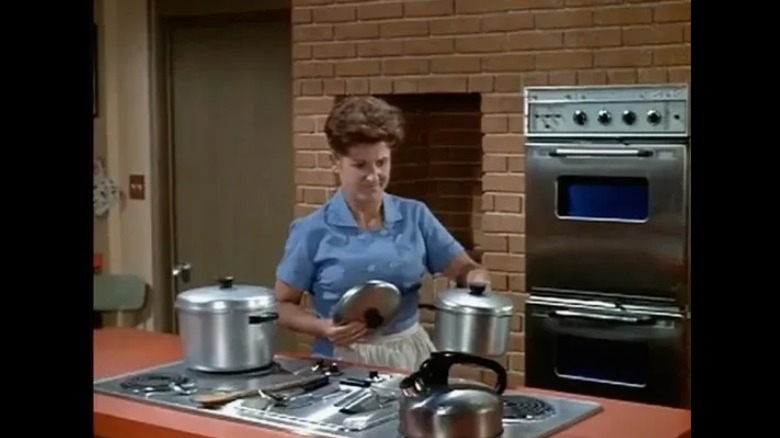 woman cooking with pots on stove