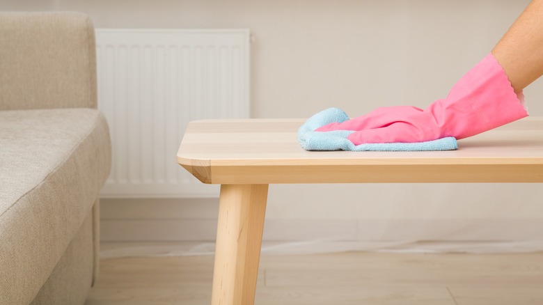 woman wiping wood table