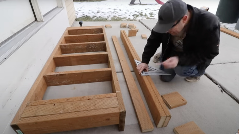 A person building a porch step frame