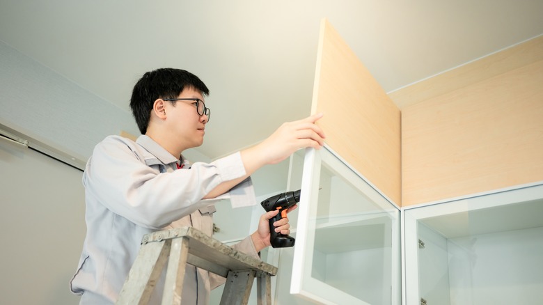 Man hanging a cabinet door