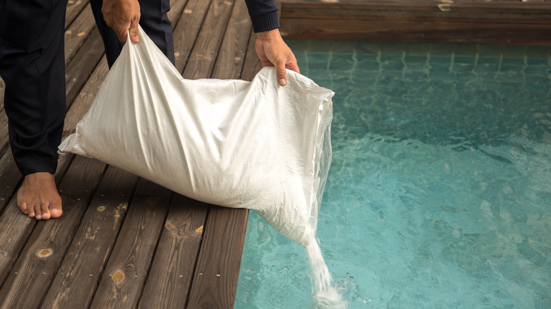 pouring bag of salt into pool