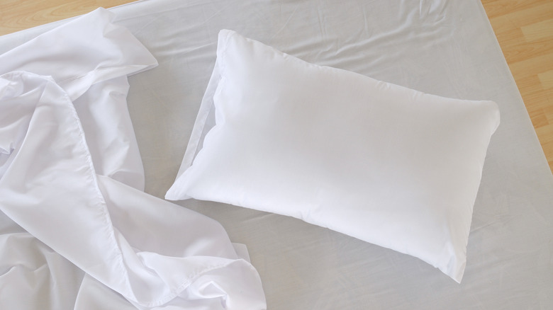 pillow and sheet on unmade bed